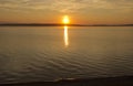 Beautiful golden orange sunset over the lake. The sun sets turning the sky yellow, orange & red tones & reflects in the lake Royalty Free Stock Photo