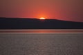 Beautiful golden orange sunset over the lake. The sun sets turning the sky yellow, orange & red tones & reflects in the lake Royalty Free Stock Photo