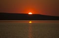 Beautiful golden orange sunset over the lake. The sun sets turning the sky yellow, orange & red tones & reflects in the lake Royalty Free Stock Photo