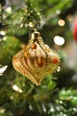Beautiful golden ornament with honey-colored drops hanging on the Christmas tree
