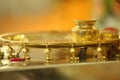 A beautiful golden Pooja thali with little bell details and a kalash