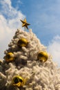 Beautiful Golden star on top of the outdoor white chrismas tree Royalty Free Stock Photo