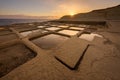 A beautiful golden sunrise landscape photograph of rock-cut salt pans