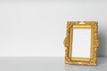 Beautiful golden vintage frame on white wooden table, space for text Royalty Free Stock Photo