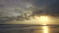 A beautiful golden yellow and dark grey stormy sunset. Bright sun shining through dark clouds at golden hour. Amazing