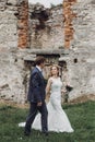 Beautiful gorgeous bride and groom walking and looking at each other . happy wedding couple embracing at old castle. happy Royalty Free Stock Photo