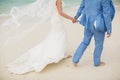 Beautiful gorgeous bride and stylish groom holding hands, on the background of a sea. Royalty Free Stock Photo