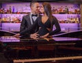 Beautiful gorgeous couple in elegant formal wear. Sexual passionate couple in luxury formal wear hugging by piano Royalty Free Stock Photo