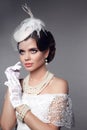 Beautiful gorgeous woman with elegant wavy hairstyle, bright make up. Fashion brunette wearing pearls jewelry, retro hat and lace