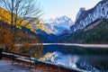 Beautiful Gosausee lake landscape with a bench, forest, clouds and reflections in the water in Austrian Alps. Royalty Free Stock Photo