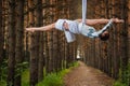 Beautiful and graceful aerial gymnast performs exercises on the air ring