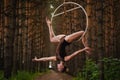 Beautiful and graceful aerial gymnast performs exercises on the air ring