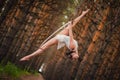 Beautiful and graceful aerial gymnast performs exercises on the air ring