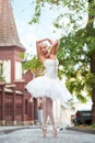 Beautiful graceful ballerina dancing on the streets of an old ci