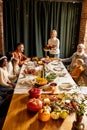 Happy Thanksgiving dinner party with family and friends with turkey and holiday traditional food, dishes on table. Royalty Free Stock Photo