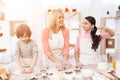 Beautiful grandmother in her apron together with her little grandsons cooks cookies in kitchen. Royalty Free Stock Photo