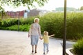 Beautiful granny and her little grandchild walking together in park