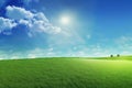 Beautiful grassy field nature landscape background with blooming glade, trees, hills and blue sky on a wonderful sunny day, Royalty Free Stock Photo