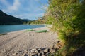 Beautiful gravel beach with rowing boats, lake walchensee bavaria. blooming apple tree in spring Royalty Free Stock Photo