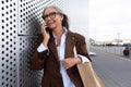 beautiful gray-haired successful mature business woman in glasses dressed in a respectable way speaks on the phone on Royalty Free Stock Photo