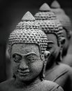 Beautiful grayscale vertical shot of the heads of Buddhist statues