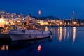 Beautiful Greek fishermen village on hilltop and by waterfront after sunset, Naoussa, Paros island, Greece.