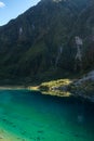 Green and blue lake with waterfall near glacier Franz Josef in New Zealand South Island Royalty Free Stock Photo