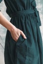 Beautiful green corduroy dress on a girl close-up. Hand on the belt