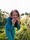 A beautiful girl in a field playing with plants. The concept of walking in nature, freedom and an eco-friendly lifestyle Royalty Free Stock Photo