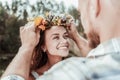 Beautiful green-eyed woman feeling extremely happy receiving nice floral chaplet