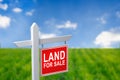 Beautiful green field and blue sky with LAND FOR SALE sign. Royalty Free Stock Photo