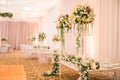 BEAUTIFUL GREEN FLORAL DECORATION AT WHITE GROOM AND BRIDE WEDDING TABLE WITH IMPRESSIVE COLOURFUL VENUE, CARPET FLOOR AND BLURRED Royalty Free Stock Photo