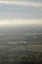 Beautiful green forests and fields pictured from airplane window with blue sky and clouds. Countryside view from airplane in the Royalty Free Stock Photo