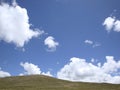 The beautiful green hillside under the blue sky and white clouds Royalty Free Stock Photo