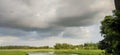 Beautiful countryside in early autumn. grassy rolling hills with some trees. wonderful cloudscape on an azure sky above the landsc