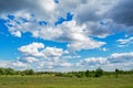 Beautiful green meadow under the blue cloudy sky during sunny day Royalty Free Stock Photo
