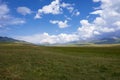 Beautiful green mountain valley with blue cloudy sky on background. Spring farm field landscape. Outdoor landscape. Sunset light. Royalty Free Stock Photo