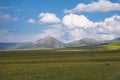 Beautiful green mountain valley with blue cloudy sky on background. Spring farm field landscape. Outdoor landscape. Sunset light. Royalty Free Stock Photo