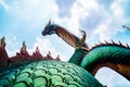 Beautiful green naga or serpent statue with blue sky and clouds