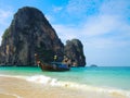 Beautiful green ocean water with wooden sightseeing boat rocky mountain in the sea, Krabi, Thailand.