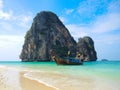 Beautiful green ocean water with wooden sightseeing boat rocky mountain in the sea, Krabi, Thailand.