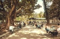 Beautiful green park with outtdor cafe and people realxing with coffee and lemonade on street