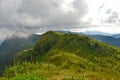 Beautiful green ridges of range under rainy clouds