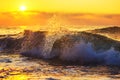 Golden sunrise and splashing blue sea waves near the beach