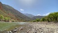 A beautiful green valley with a mountain river. Green hills, blue sky and white clouds Royalty Free Stock Photo