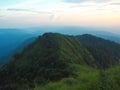 Beautiful greenery landscape by mountain and sunset sky with grassland. Royalty Free Stock Photo