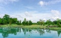 Beautiful greenery landscapes of water garden in a park, green leaf of Lotus in a lake beside green lawn and trees under cloudy Royalty Free Stock Photo