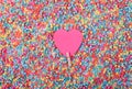 Beautiful greeting card design of Sweet Pink Heart pinned with a clothes peg in a sea of multicoloured beads. Copy Space for Texts