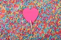 Beautiful greeting card design of Sweet Pink Heart pinned with a clothes peg in a sea of multicoloured beads. Copy Space for Texts