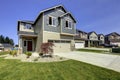 Beautiful grey house exterior with stone, green lawn and driveway.